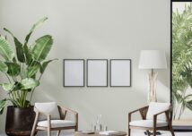 poster frames in room interior with light neutral wall with sunlight and wooden furniture with tropical plant and palm leaves, 3d rendering