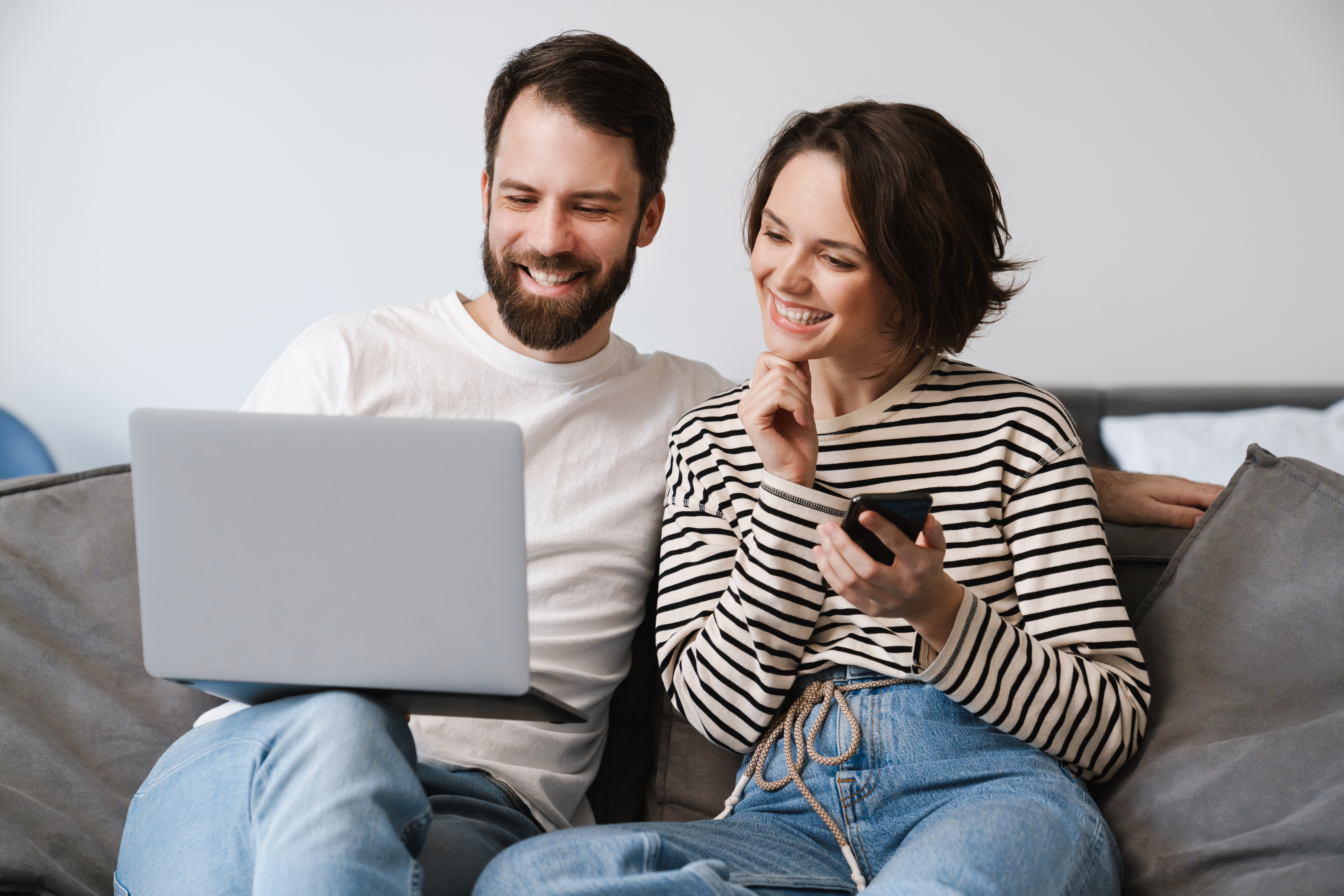 Happy young white couple sitting on a couch at home