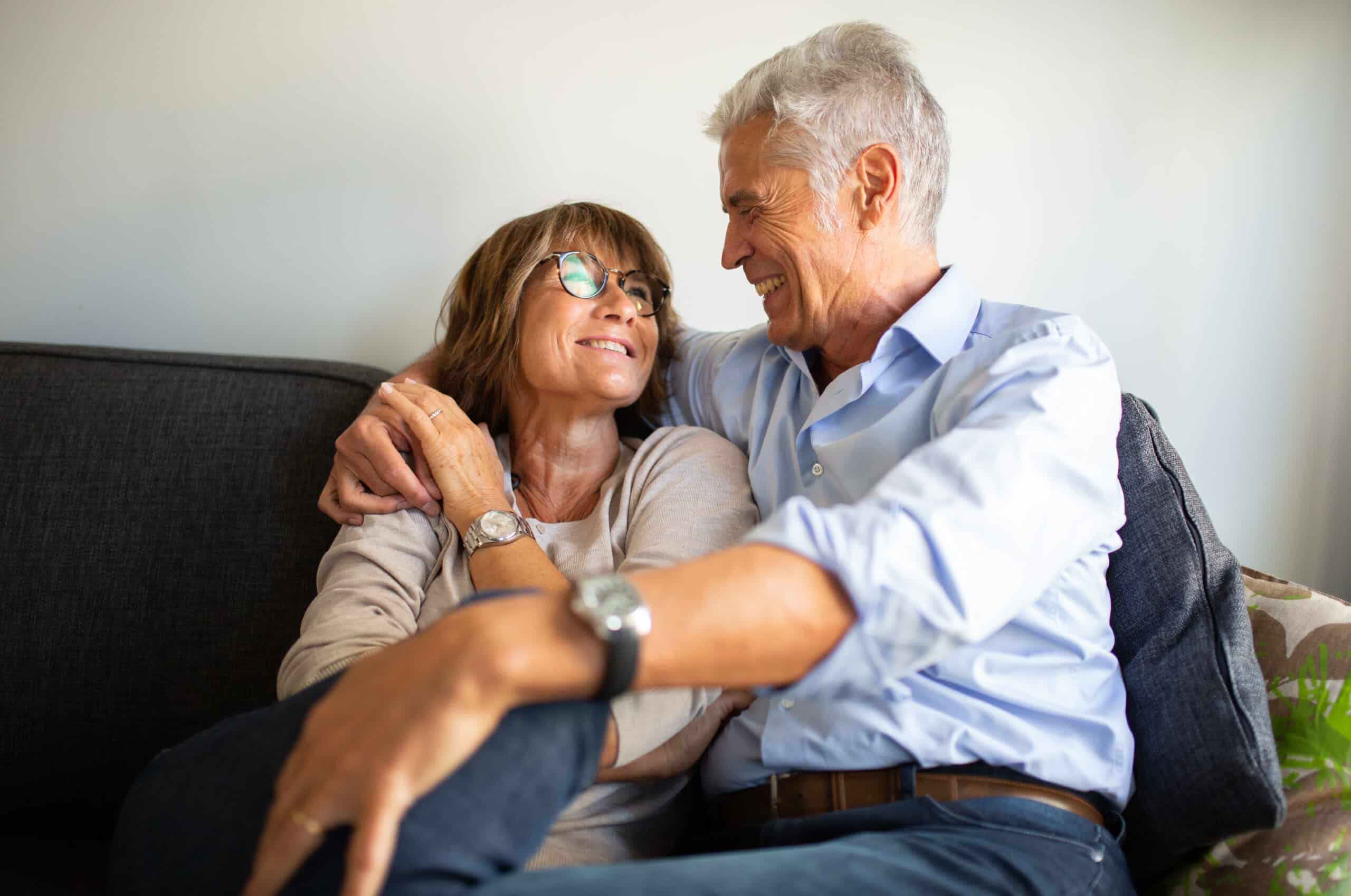 loving older couple sitting on sofa